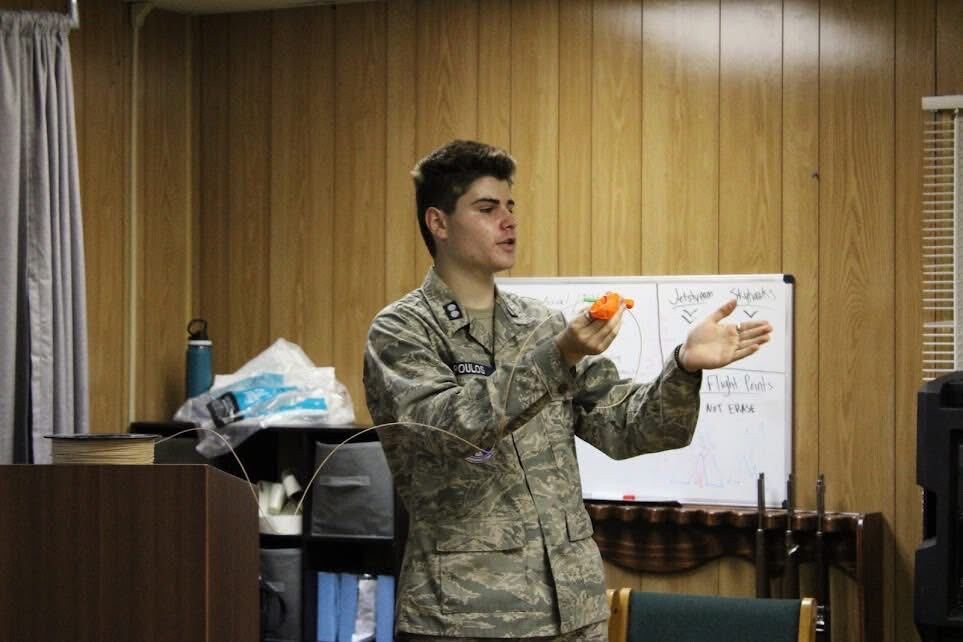 A cadet leading a classroom lesson at the whiteboard during a weekly squadron meeting