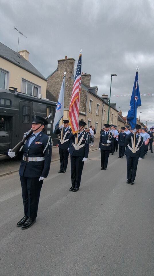 Clearwater Composite Squadron color guard standing at attention in a village street in France