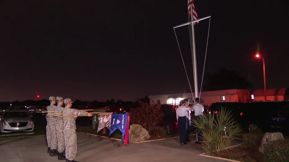 Clearwater Composite Squadron cadets standing at attention with squadron guidons during an evening flag ceremony