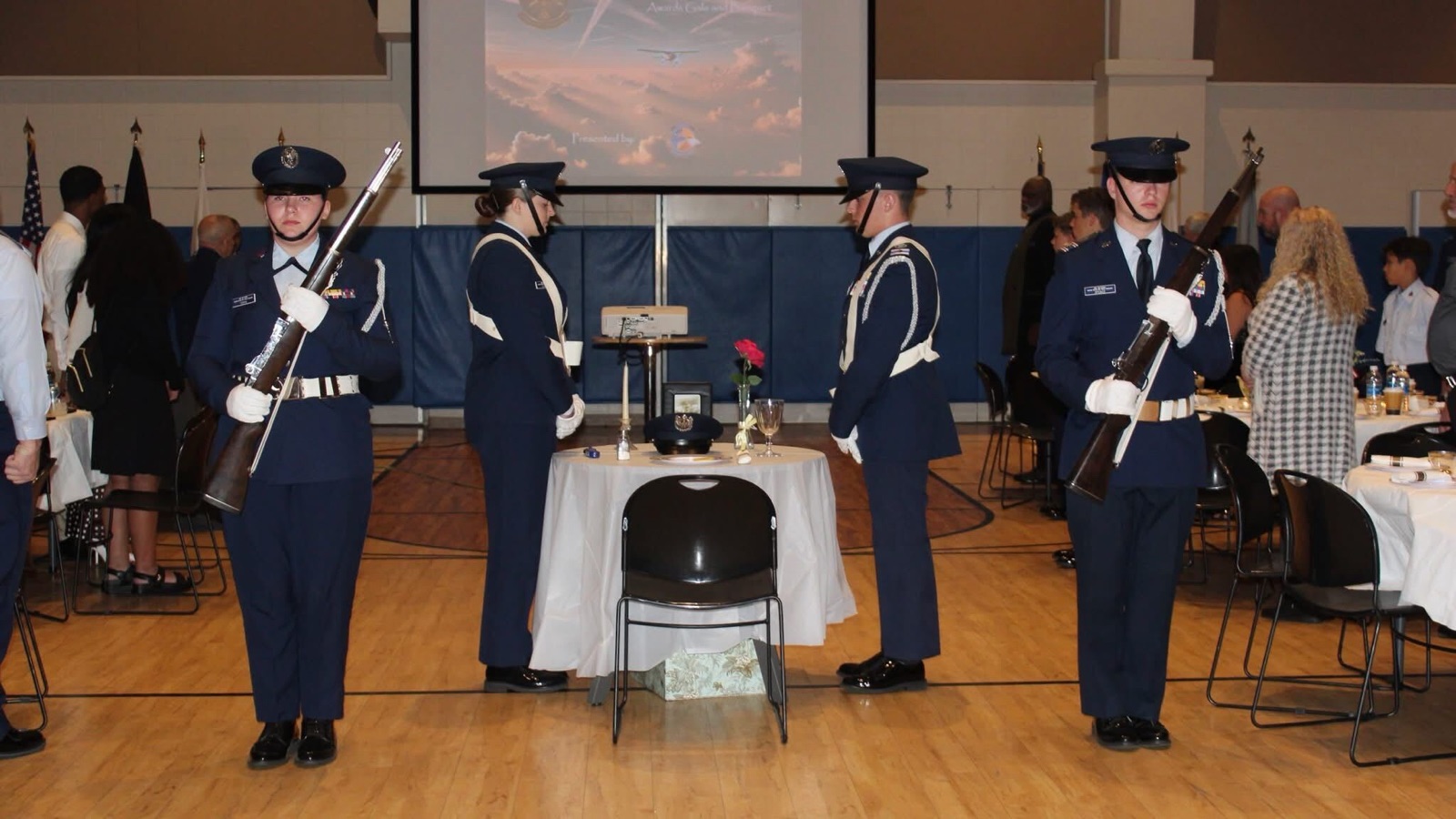 Cadet honor guard members posted around a remembrance table during a squadron banquet